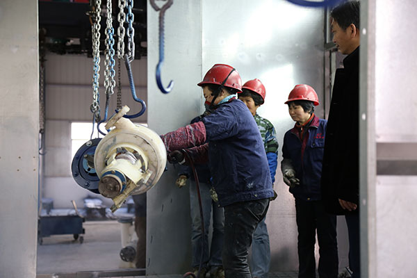 老師觀察公司員工進行噴漆作業(yè)